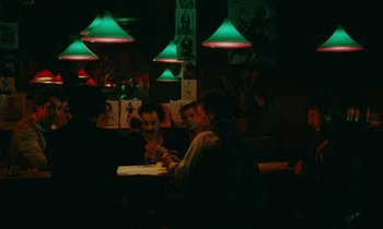 Movie still from “So Long, Stooge” (1983), directed by Claude Berri – A group of people sitting at a table in a restaurant; Wide shot, Over the shoulder angle