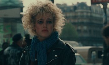 Movie still from “So Long, Stooge” (1983), directed by Claude Berri – A woman in a black jacket and a blue scarf; Close Up shot, Over the shoulder angle