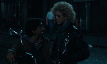 Movie still from “So Long, Stooge” (1983), directed by Claude Berri – A man and a woman standing next to each other on the street; Medium shot, Over the shoulder angle