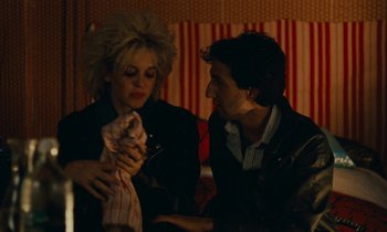 Movie still from “So Long, Stooge” (1983), directed by Claude Berri – A man and a woman sitting next to each other in a room; Medium shot, High angle