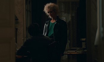 Movie still from “So Long, Stooge” (1983), directed by Claude Berri – Two people standing in a dark room talking to each other; Medium shot, Over the shoulder angle