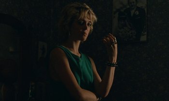 Movie still from “So Long, Stooge” (1983), directed by Claude Berri – A woman in a green dress is holding a cigarette; Medium shot, Over the shoulder angle