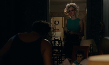 Movie still from “So Long, Stooge” (1983), directed by Claude Berri – A woman standing in front of two other people; Medium shot, Over the shoulder angle