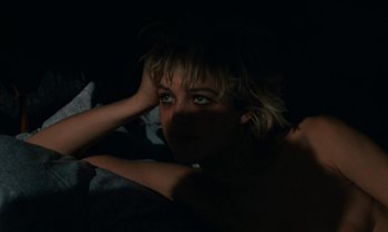 Movie still from “So Long, Stooge” (1983), directed by Claude Berri – A young woman is sitting in a dark room; Close Up shot, Overhead angle
