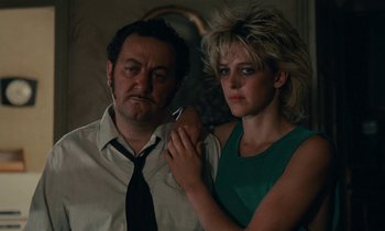 Movie still from “So Long, Stooge” (1983), directed by Claude Berri – A man and a woman pose for a picture; Close Up shot, Low angle