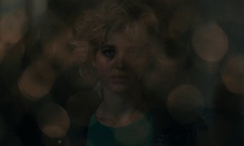 Movie still from “So Long, Stooge” (1983), directed by Claude Berri – A woman with blonde hair is looking at the camera; Close Up shot, Low angle