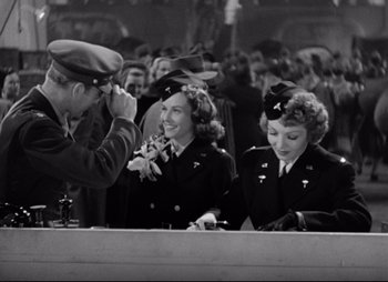 Movie still from “So Proudly We Hail” (1990), directed by Lionel Chetwynd – Two women in military uniforms are sitting at a table; Medium shot, Low angle