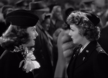 Movie still from “So Proudly We Hail” (1990), directed by Lionel Chetwynd – Two women are talking to each other in a crowd of people; Close Up shot, Over the shoulder angle