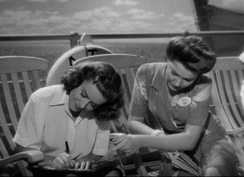 Movie still from “So Proudly We Hail” (1990), directed by Lionel Chetwynd – A couple of women sitting next to each other on a bench; Medium shot, High angle