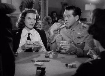 Movie still from “So Proudly We Hail” (1990), directed by Lionel Chetwynd – A man and a woman sitting at a table; Medium shot, Over the shoulder angle