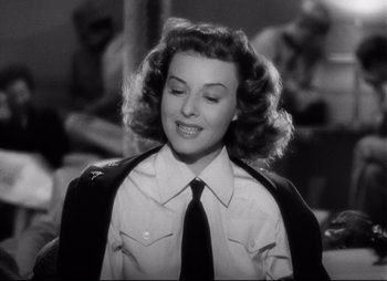 Movie still from “So Proudly We Hail” (1990), directed by Lionel Chetwynd – A black and white photo of a woman wearing a tie; Close Up shot, Low angle