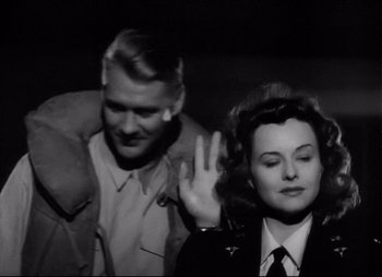 Movie still from “So Proudly We Hail” (1990), directed by Lionel Chetwynd – A man and a woman are standing next to each other; Medium shot, Over the shoulder angle