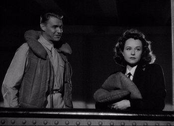 Movie still from “So Proudly We Hail” (1990), directed by Lionel Chetwynd – A man and a woman standing next to each other; Medium shot, Low angle