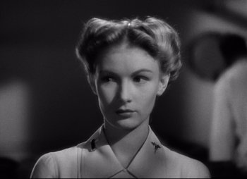 Movie still from “So Proudly We Hail” (1990), directed by Lionel Chetwynd – A black and white photo of a woman in a military uniform; Close Up shot, Low angle