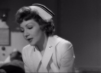 Movie still from “So Proudly We Hail” (1990), directed by Lionel Chetwynd – An old photo of a woman wearing a nurse's uniform; Close Up shot, Over the shoulder angle