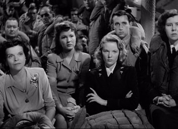 Movie still from “So Proudly We Hail” (1990), directed by Lionel Chetwynd – A black and white photo of a group of people; Medium shot, Low angle