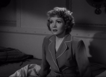 Movie still from “So Proudly We Hail” (1990), directed by Lionel Chetwynd – An old photo of a woman sitting on a bench; Medium shot, High angle