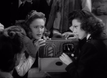 Movie still from “So Proudly We Hail” (1990), directed by Lionel Chetwynd – Two women are looking at an electronic device; Medium shot, Over the shoulder angle