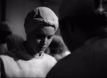 Movie still from “So Proudly We Hail” (1990), directed by Lionel Chetwynd – A black and white photo of a woman wearing a head covering; Close Up shot, Low angle