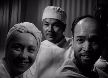 Movie still from “So Proudly We Hail” (1990), directed by Lionel Chetwynd – A black and white photo of three people; Close Up shot, Low angle