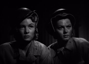 Movie still from “So Proudly We Hail” (1990), directed by Lionel Chetwynd – A couple of women standing next to each other; Close Up shot, Low angle