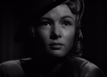 Movie still from “So Proudly We Hail” (1990), directed by Lionel Chetwynd – A black and white photo of a woman in a hat; Close Up shot, Low angle