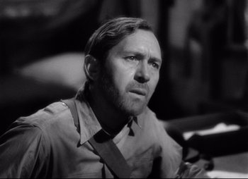 Movie still from “So Proudly We Hail” (1990), directed by Lionel Chetwynd – Black and white photograph of a man looking at the camera; Close Up shot, Low angle