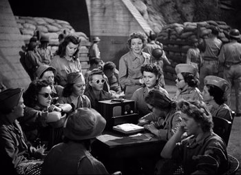 Movie still from “So Proudly We Hail” (1990), directed by Lionel Chetwynd – A group of women sitting around a table; Wide shot, High angle
