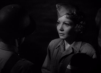 Movie still from “So Proudly We Hail” (1990), directed by Lionel Chetwynd – A woman in a military uniform looking at the camera; Close Up shot, Over the shoulder angle