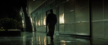 Movie still from “Solaris” (2002), directed by Steven Soderbergh – A man walking down a wet walkway in the dark; Wide shot, Low angle