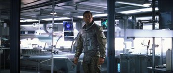 Movie still from “Solaris” (2002), directed by Steven Soderbergh – A man standing in a room wearing a space suit; Medium shot, Low angle