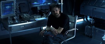 Movie still from “Solaris” (2002), directed by Steven Soderbergh – A man sitting in a chair in front of a computer monitor; Medium shot, High angle