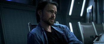 Movie still from “Solaris” (2002), directed by Steven Soderbergh – A person sitting in a chair; Close Up shot, Over the shoulder angle