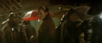 Movie still from “Solaris” (2002), directed by Steven Soderbergh – A woman standing in the rain holding an umbrella; Close Up shot, Over the shoulder angle
