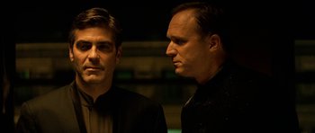 Movie still from “Solaris” (2002), directed by Steven Soderbergh – Two men standing next to each other in front of a wall; Close Up shot, Over the shoulder angle