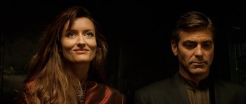 Movie still from “Solaris” (2002), directed by Steven Soderbergh – A woman and a man standing next to each other in front of a black background; Close Up shot, Low angle