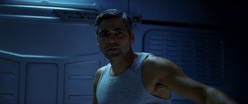 Movie still from “Solaris” (2002), directed by Steven Soderbergh – A man in a white tank top is looking at the camera; Close Up shot, Low angle