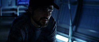 Movie still from “Solaris” (2002), directed by Steven Soderbergh – A man with a beard wearing a baseball cap; Close Up shot, Over the shoulder angle