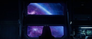 Movie still from “Solaris” (2002), directed by Steven Soderbergh – A woman looking out a window at the sky at night time; Extreme Wide shot, Overhead angle
