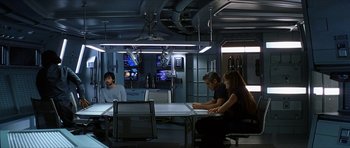 Movie still from “Solaris” (2002), directed by Steven Soderbergh – A group of people sitting at a table in a room; Wide shot, High angle