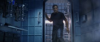 Movie still from “Solaris” (2002), directed by Steven Soderbergh – A man standing inside of a room with a bunch of drawers; Medium shot, Low angle