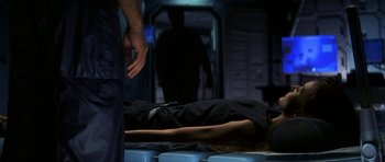 Movie still from “Solaris” (2002), directed by Steven Soderbergh – A person lying on the ground in a dark room; Medium shot, High angle