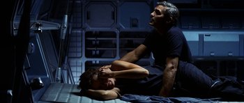 Movie still from “Solaris” (2002), directed by Steven Soderbergh – A man and a woman are laying on the ground; Medium shot, Overhead angle