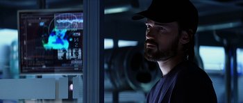 Movie still from “Solaris” (2002), directed by Steven Soderbergh – A man with a beard wearing a black hat; Close Up shot, Low angle