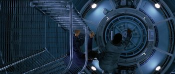 Movie still from “Solaris” (2002), directed by Steven Soderbergh – Two people climbing up a spiral staircase in a building; Wide shot, Overhead angle