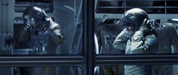 Movie still from “Solaris” (2002), directed by Steven Soderbergh – Two men in space suits are reflected in a window; Medium shot, Over the shoulder angle