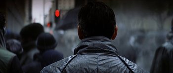 Movie still from “Solaris” (2002), directed by Steven Soderbergh – A man wearing a black jacket and holding an umbrella in the rain; Close Up shot, Over the shoulder angle