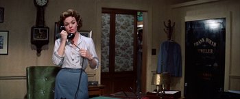Movie still from “Some Came Running” (1958), directed by Vincente Minnelli – A woman standing in front of a microphone in a room; Medium shot, Low angle