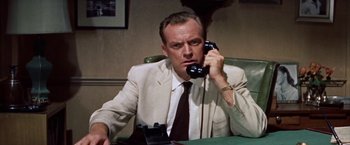 Movie still from “Some Came Running” (1958), directed by Vincente Minnelli – A man sitting at a table talking on a phone; Close Up shot, Low angle