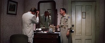 Movie still from “Some Came Running” (1958), directed by Vincente Minnelli – A man in a suit is looking in the mirror; Medium shot, Over the shoulder angle